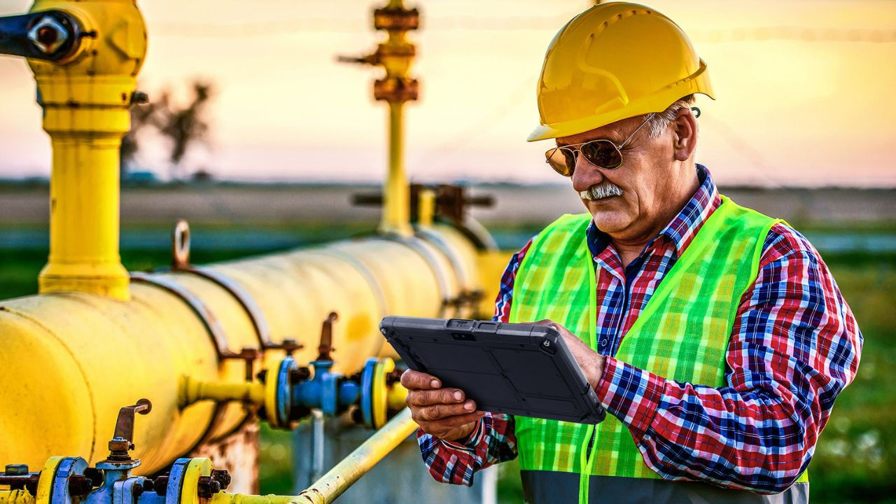 utility worker inspecting a facility while holding a Getac rugged tablet