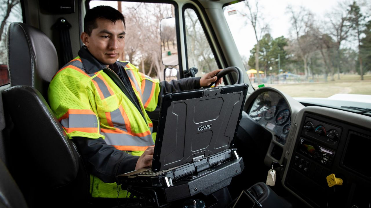 utility worker accessing data with Getac rugged laptop inside the vehicle