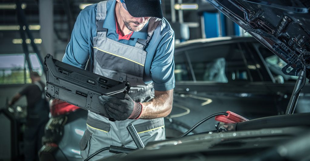 vehicle technician inspecting car hood
